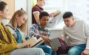 Teens gathering around reading